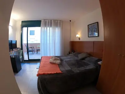 a bedroom with a large bed with a red blanket at Sitges rooms by Sitges Apartment in Sitges