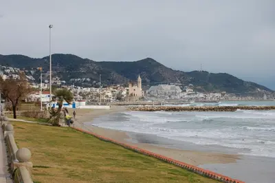 a view of a beach with the ocean and buildings at Sitges rooms by Sitges Apartment in Sitges