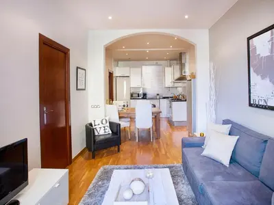 a living room with a blue couch and a kitchen at Apartment in Barcelona near Seabeach in Barcelona