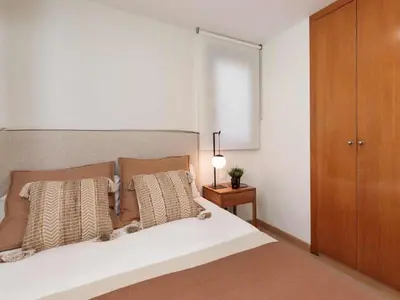 a bed with a table with a lamp and a plant on it at Penthouse in Barcelona with Large Terrace in Barcelona