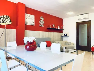a dining room with a table and a red wall at La Pedrera Residence in Barcelona