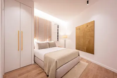 a white bedroom with a bed and a painting on the wall at The Diagonal Suites by Sweett in Barcelona