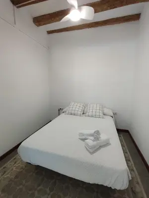a bedroom with a white bed with towels on it at Canonge Rodó Apartments in Barcelona