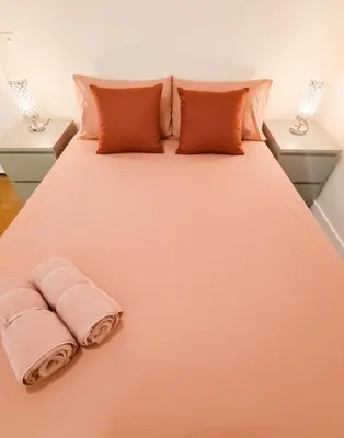 a bed with two towels on it with two lamps at Centric Rooms Ghotic in Barcelona