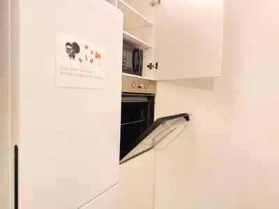 a kitchen with white cabinets and a black oven at Centric Rooms Ghotic in Barcelona