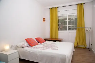 a bedroom with a bed with orange pillows and a window at GranVia Fira Apartment in Hospitalet de Llobregat