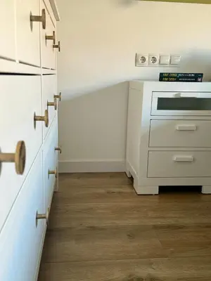 a kitchen with white cabinets and wooden floors at Apartamento Ideal en Poblenou in Barcelona