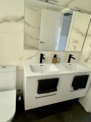 a white bathroom with two sinks and a mirror at Apartamento Ideal en Poblenou in Barcelona