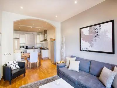 a living room with a blue couch and a kitchen at Premium apartment in Barcelona in Barcelona
