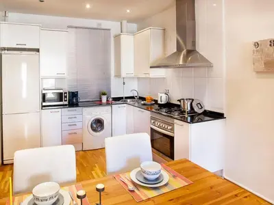 a kitchen with white cabinets and a table with chairs at Premium apartment in Barcelona in Barcelona