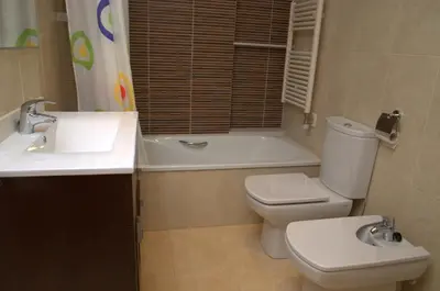 a bathroom with a toilet and a sink and a tub at Apartamentos Navas 2 in Barcelona