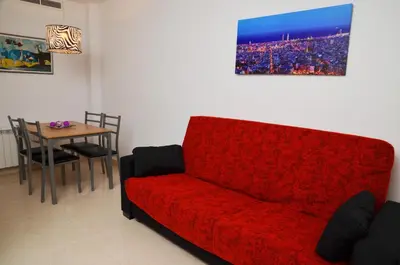 a living room with a red couch and a table at Apartamentos Navas 2 in Barcelona