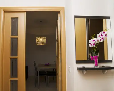 a hallway with a mirror and a vase with flowers at Apartamentos Navas 2 in Barcelona