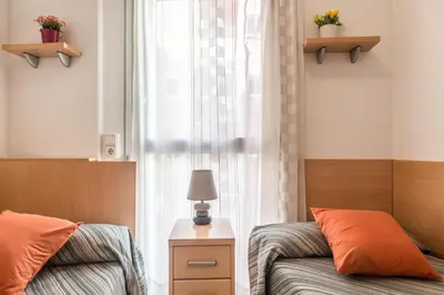 a bedroom with two beds and a window at Apartamentos Navas 2 in Barcelona