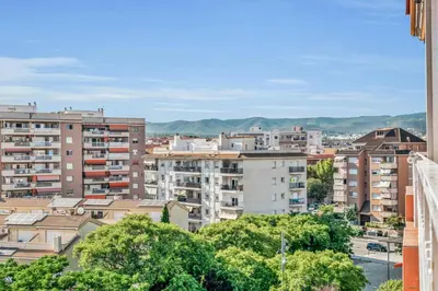 a city with buildings and mountains in the background at Sea View Penthouse in Vilanova i la Geltrú