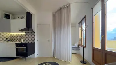 a kitchen with white walls and a door to a bedroom at Atico Central con Terraza in Barcelona