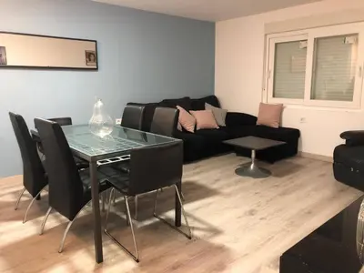 a living room with a table and a couch at Vila Peña Private Apartment with Shared Pool & Gardens in Cubelles
