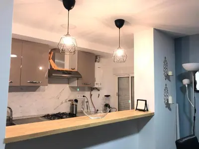 a kitchen with three pendant lights over a counter at Vila Peña Private Apartment with Shared Pool & Gardens in Cubelles