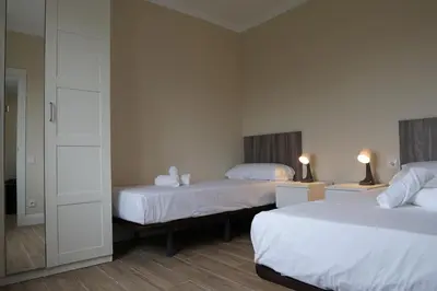 a hotel room with two beds and a mirror at RIUS33 - Huge & Spacious Apartment in Montjuic in Barcelona