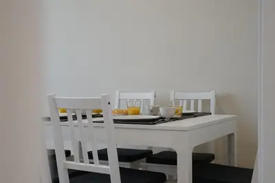 a white table with two chairs and a table with two cups at RIUS33 - Huge & Spacious Apartment in Montjuic in Barcelona