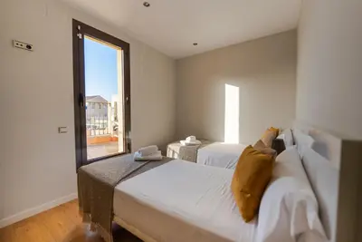 a bedroom with two beds and a large window at Ático con terraza en el corazón de Barcelona in Barcelona