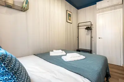 a small bedroom with a bed with white sheets at Joan Blanques Apartment in Barcelona