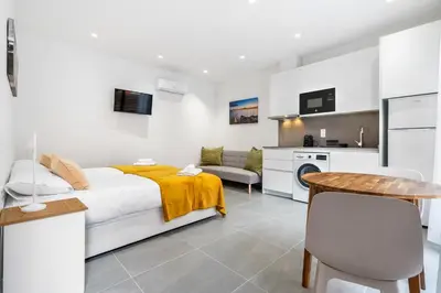 a bedroom with a bed and a table and a kitchen at Fira Building in Hospitalet de Llobregat