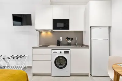 a kitchen with a washing machine in a white kitchen at Fira Building in Hospitalet de Llobregat