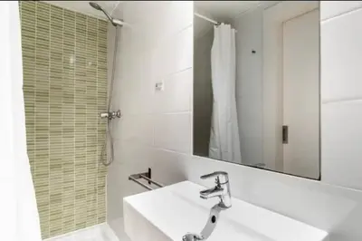 a white bathroom with a sink and a mirror at Stylish apartment in Plaça Espanya in Barcelona