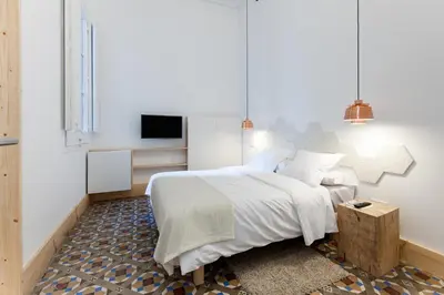 a bedroom with a large bed and a tv at La Casa de Antonio Boutique Rooms in Barcelona