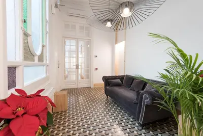 a living room with a black couch and a red flower at La Casa de Antonio Boutique Rooms in Barcelona