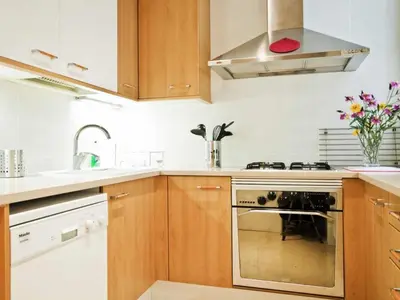 a kitchen with wooden cabinets and a stove top oven at Apartamento con 2 Dormitorios, Elegante y Céntrico en Rambla Catalunya - ES-341-2 in Barcelona
