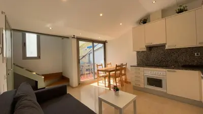 a kitchen and living room with a couch and a table at SE Céntrico con Terraza in Terrassa