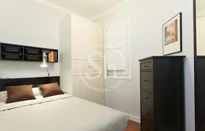 a bedroom with a bed and a dresser and a window at Bonito apartamento 3 in Barcelona