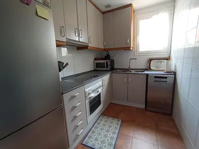 a small kitchen with white cabinets and a window at Esplendida casa en Valldoreix in Sant Cugat del Vallès