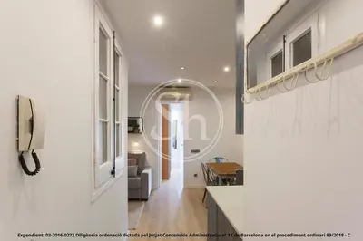a hallway with a living room with a couch and a window at Wonderful apartment in Barcelona