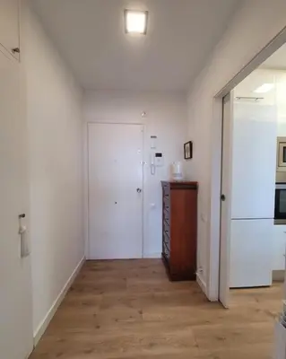 a room with a hallway with white walls and wooden floors at Apartamento Bonavista in Vilassar de Mar