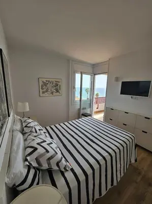 a bedroom with a bed with a striped blanket at Apartamento Bonavista in Vilassar de Mar