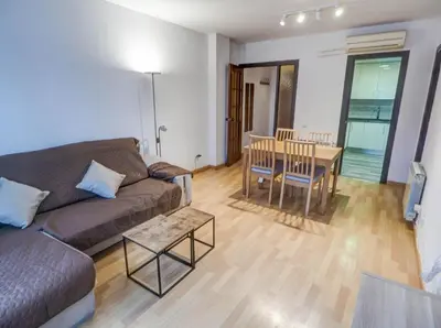 a living room with a couch and a table at Bambino apartment by Hello Homes Sitges in Sitges