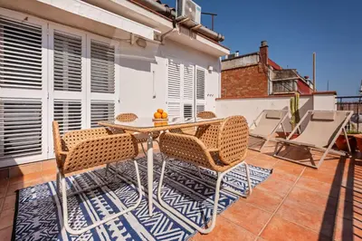 a patio with a table and chairs on a balcony at Sweett - Atic Gracia in Barcelona