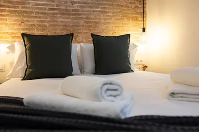 a bedroom with a bed with towels on it at Stay U-nique Apartment Astúries in Barcelona