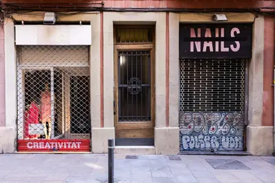 a store front with a door with graffiti on it at Stay U-nique Apartment Astúries in Barcelona