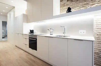 a kitchen with white cabinets and a sink at Stay U-nique Apartment Astúries in Barcelona