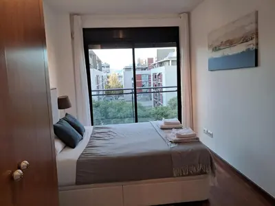 a bedroom with a bed and a large window at Modern apartment, with parking, close to the beach!! in Sant Adria de Besos