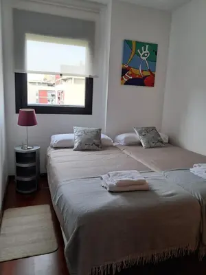 two beds in a room with a window at Modern apartment, with parking, close to the beach!! in Sant Adria de Besos