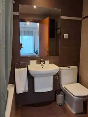 a bathroom with a sink and a toilet and a mirror at Modern apartment, with parking, close to the beach!! in Sant Adria de Besos