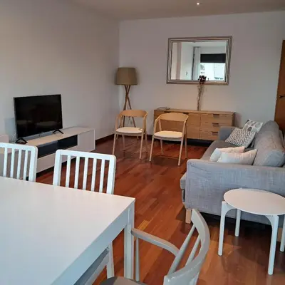 a living room with a couch and a table and chairs at Modern apartment, with parking, close to the beach!! in Sant Adria de Besos