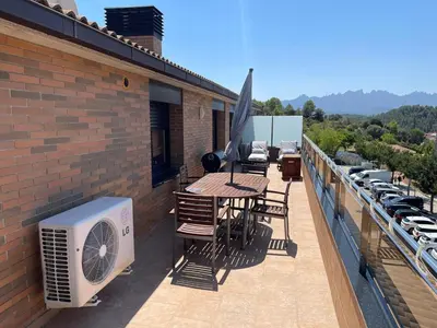 a balcony with a table and an air conditioner at DUPLEX LUMINOSO Y TRANQUILo in El Pont de Vilomara