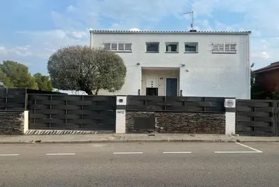 a white house with a black fence in front of it at CASA CON JARDIN, SAUNA, PISCINA PRIVADA y NATURALEZA CERCA DE BARCELONA in Pallejá