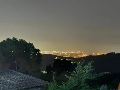 a view of a city at night at CASA CON JARDIN, SAUNA, PISCINA PRIVADA y NATURALEZA CERCA DE BARCELONA in Pallejá